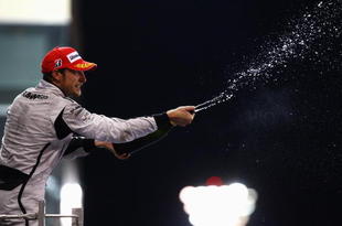 ABU DHABI, UNITED ARAB EMIRATES - NOVEMBER 01:  Jenson Button of Great Britain and Brawn GP celebrates on the podium after finishing third during the Abu Dhabi Formula One Grand Prix at the Yas Marina Circuit on November 1, 2009 in Abu Dhabi, United Arab Emirates.  (Photo by Paul Gilham/Getty Images)