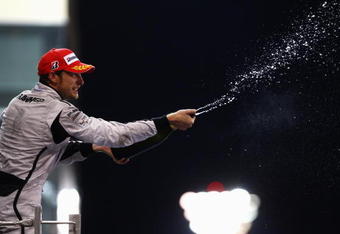 ABU DHABI, UNITED ARAB EMIRATES - NOVEMBER 01:  Jenson Button of Great Britain and Brawn GP celebrates on the podium after finishing third during the Abu Dhabi Formula One Grand Prix at the Yas Marina Circuit on November 1, 2009 in Abu Dhabi, United Arab Emirates.  (Photo by Paul Gilham/Getty Images)