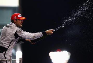 ABU DHABI, UNITED ARAB EMIRATES - NOVEMBER 01:  Jenson Button of Great Britain and Brawn GP celebrates on the podium after finishing third during the Abu Dhabi Formula One Grand Prix at the Yas Marina Circuit on November 1, 2009 in Abu Dhabi, United Arab Emirates.  (Photo by Paul Gilham/Getty Images)