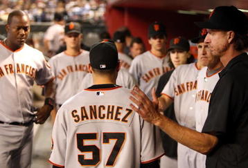 PHOENIX - JUNE 11:  Starting pitcher Jonathan Sanchez #57 of the San Francisco Giants is greeted by Randy Johnson (R) and teammates after being removed from the major league baseball game against the Arizona Diamondbacks at Chase Field on June 11, 2009 in Phoenix, Arizona.  The Diamondbacks defeated the Giants 2-1. (Photo by Christian Petersen/Getty Images)