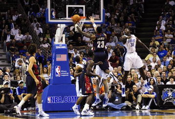 ORLANDO, FL - NOVEMBER 11:  LeBron James #23 of the Cleveland Cavaliers goes to the basket against Brandon Bass #30 of the Orlando Magic during the game on November 11, 2009 at Amway Arena in Orlando, Florida. NOTE TO USER: User expressly acknowledges and agrees that, by downloading and/or using this Photograph, user is consenting to the terms and conditions of the Getty Images License Agreement. (Photo by Sam Greenwood/Getty Images)