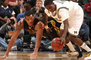 INDIANAPOLIS - MARCH 12:  Manny Harris #3 of the Michigan Wolveriens attempts to control a loose ball against Jarryd Cole #50 of the Iowa Hawkeyes during the first round of the Big Ten Men's Basketball Tournament at Conseco Fieldhouse on March 12, 2009 in Indianapolis, Indiana.  (Photo by Jonathan Daniel/Getty Images)