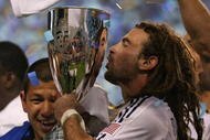 BRIDGEVIEW, IL - NOVEMBER 14: Kyle Beckerman #5 of Real Salt Lake kisses the trophy as goalkeeper Nick Rimando #18 celebrates after a win over the Chicago Fire during the MLS Eastern Conference Championship at Toyota Park on November 14, 2009 in Bridgeview, Illinois. Real Salt Lake defeated the Fire 0-0 (5-4) in a shoot-out. (Photo by Jonathan Daniel/Getty Images)