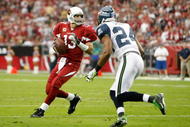 GLENDALE, AZ - NOVEMBER 15:  Quarterback Kurt Warner #13 of the Arizona Cardinals drops back to pass while being defended by Deon Grant #24 of the Seattle Seahawks in the second half at University of Phoenix Stadium on November 15, 2009 in Glendale, Arizona. The Cardinals defeated the Seahawks 31-20.  (Photo by Jeff Gross/Getty Images)