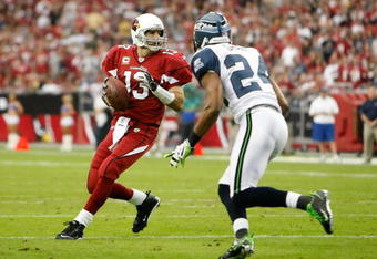 GLENDALE, AZ - NOVEMBER 15:  Quarterback Kurt Warner #13 of the Arizona Cardinals drops back to pass while being defended by Deon Grant #24 of the Seattle Seahawks in the second half at University of Phoenix Stadium on November 15, 2009 in Glendale, Arizona. The Cardinals defeated the Seahawks 31-20.  (Photo by Jeff Gross/Getty Images)