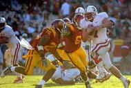 LOS ANGELES, CA - NOVEMBER 14:  Toby Gerhart #7 of the Stanford Cardinalis is chased by Will Harris #26 and Malcolm Smith #6 of the USC Trojans during the second half at the Los Angeles Memorial Coliseum on November 14, 2009 in Los Angeles, California.  Stanford won 55-21.  (Photo by Harry How/Getty Images)