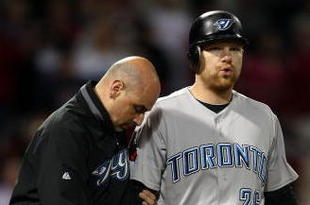 BOSTON - SEPTEMBER 29:  Adam Lind #26 of the Toronto Blue Jays is looked after by a member of the medical staff after he was hit by a pitch in the ninth inning against the Boston Red Sox on September 29, 2009 at Fenway Park in Boston, Massachusetts. The Blue Jays defeated the Red Sox 8-7.  (Photo by Elsa/Getty Images)