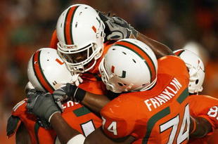 FORT LAUDERDALE, FL - OCTOBER 03: Wide receiver Travis Benjamin #3 of the Miami Hurricanes celebrates his touchdown with teammates Joel Figueroa #61 and Orlando Franklin #74 against the Oklahoma Sooners at Land Shark Stadium on October 3, 2009 in Fort Lauderdale, Florida. Miami defeated Oklahoma 21-20. (Photo by Doug Benc/Getty Images)
