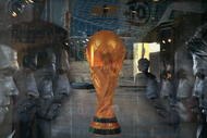 BEIJING, CHINA - JUNE 5: (CHINA OUT) An attendant is seen through a show window featuring football stars and the World Cup trophy at an adidas shop on June 5, 2006 in Beijing, China. Billboards and decorations featuring imagery relating to the World Cup, which starts June 9 in Germany, are being displayed on many Beijing streets as the event is seen as a great opportunity for local businesses, according to local media. (Photo by China Photos/Getty Images)