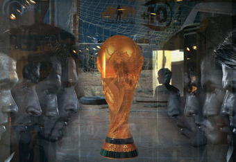 BEIJING, CHINA - JUNE 5: (CHINA OUT) An attendant is seen through a show window featuring football stars and the World Cup trophy at an adidas shop on June 5, 2006 in Beijing, China. Billboards and decorations featuring imagery relating to the World Cup, which starts June 9 in Germany, are being displayed on many Beijing streets as the event is seen as a great opportunity for local businesses, according to local media. (Photo by China Photos/Getty Images)
