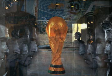 BEIJING, CHINA - JUNE 5: (CHINA OUT) An attendant is seen through a show window featuring football stars and the World Cup trophy at an adidas shop on June 5, 2006 in Beijing, China. Billboards and decorations featuring imagery relating to the World Cup, which starts June 9 in Germany, are being displayed on many Beijing streets as the event is seen as a great opportunity for local businesses, according to local media. (Photo by China Photos/Getty Images)