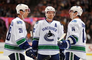 ANAHEIM, CA - OCTOBER 30:  Mikael Samuelsson #26, Henrik Sedin #33 and Alexandre Burrows #14 of the Vancouver Canucks confer during a break in game action against the Anaheim Ducks during their game at the Honda Center on October 30, 2009 in Anaheim, California. The Ducks defeated the Canucks 7-2.  (Photo by Harry How/Getty Images)