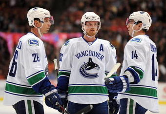ANAHEIM, CA - OCTOBER 30:  Mikael Samuelsson #26, Henrik Sedin #33 and Alexandre Burrows #14 of the Vancouver Canucks confer during a break in game action against the Anaheim Ducks during their game at the Honda Center on October 30, 2009 in Anaheim, California. The Ducks defeated the Canucks 7-2.  (Photo by Harry How/Getty Images)