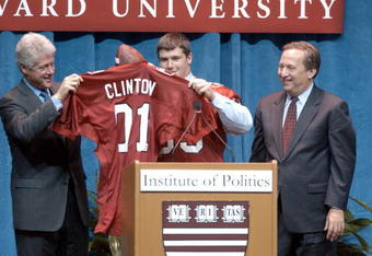 397506 02: Former US President Bill Clinton (L) receives a Harvard football jersey from a student November 19, 2001 at Harvard University in Cambridge, MA. At (R) is Harvard University President Lawrence Summers. Clinton spoke to Harvard students on the topics of globalization and politics in his first speech in the Boston area since leaving office. (Photo by Darren McCollester/Getty Images)