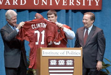 397506 02: Former US President Bill Clinton (L) receives a Harvard football jersey from a student November 19, 2001 at Harvard University in Cambridge, MA. At (R) is Harvard University President Lawrence Summers. Clinton spoke to Harvard students on the topics of globalization and politics in his first speech in the Boston area since leaving office. (Photo by Darren McCollester/Getty Images)
