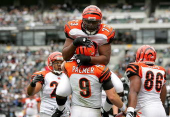 OAKLAND, CA - NOVEMBER 22:  Anthony Collins #73 jumps on Carson Palmer #9 of the Cincinnati Bengals after Palmer rushed in for a touchdown against the Oakland Raiders at Oakland-Alameda County Coliseum on November 22, 2009 in Oakland, California.  (Photo by Ezra Shaw/Getty Images)