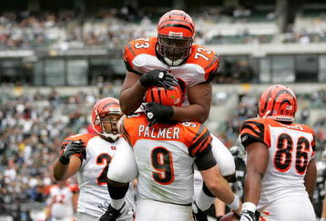 OAKLAND, CA - NOVEMBER 22:  Anthony Collins #73 jumps on Carson Palmer #9 of the Cincinnati Bengals after Palmer rushed in for a touchdown against the Oakland Raiders at Oakland-Alameda County Coliseum on November 22, 2009 in Oakland, California.  (Photo by Ezra Shaw/Getty Images)
