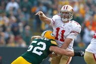 GREEN BAY, WI - NOVEMBER 22: Quarterback Alex Smith #11 of the San Francisco 49ers passes the football as he is hit by linebacker Clay Matthews #52 of the Green Bay Packers at Lambeau Field on November 22, 2009 in Green Bay, Wisconsin. (Photo by Scott Boehm/Getty Images)