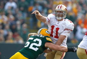 GREEN BAY, WI - NOVEMBER 22: Quarterback Alex Smith #11 of the San Francisco 49ers passes the football as he is hit by linebacker Clay Matthews #52 of the Green Bay Packers at Lambeau Field on November 22, 2009 in Green Bay, Wisconsin. (Photo by Scott Boehm/Getty Images)
