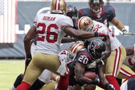 HOUSTON - OCTOBER 25:  Running back Steve Slaton #20 of the Houston Texans is tackled by linebacker Patrick Willis #52 and Mark Roman #26 of the San Francisco 49ers at Reliant Stadium on October 25, 2009 in Houston, Texas.  (Photo by Bob Levey/Getty Images)