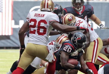 HOUSTON - OCTOBER 25:  Running back Steve Slaton #20 of the Houston Texans is tackled by linebacker Patrick Willis #52 and Mark Roman #26 of the San Francisco 49ers at Reliant Stadium on October 25, 2009 in Houston, Texas.  (Photo by Bob Levey/Getty Images)