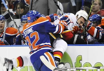 EDMONTON, AB - OCTOBER 3:  Center Ryan Stone #32 of the Edmonton Oilers checking defenseman Mark Giordano #5 of the Calgary Flames into the bench in the second period during an NHL game on October 3, 2009 at Rexall Arena in Edmonton, Canada. (Photo by Jimmy Jeong/Getty Images)
