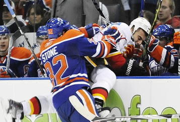 EDMONTON, AB - OCTOBER 3:  Center Ryan Stone #32 of the Edmonton Oilers checking defenseman Mark Giordano #5 of the Calgary Flames into the bench in the second period during an NHL game on October 3, 2009 at Rexall Arena in Edmonton, Canada. (Photo by Jimmy Jeong/Getty Images)