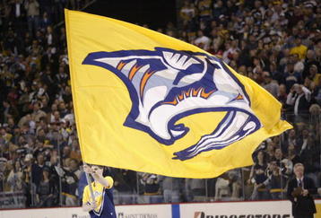 NASHVILLE - APRIL 13:  A Nashville Predators flag is paraded around the rink during a break in game four of the first round of the  2004 Stanley Cup playoffs against the Detroit Red Wings on April 13, 2004 at the Gaylord Center in Nashville, Tennessee. (Photo by Brian Bahr/Getty Images)