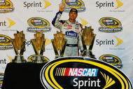 HOMESTEAD, FL - NOVEMBER 22: Jimmie Johnson, driver of the #48 Lowe's Chevrolet, poses with all four of his championship trophies after winning the NASCAR Sprint Cup Series Championship at Homestead-Miami Speedway on November 22, 2009 in Homestead, Florida. Johnson becomes the first driver in the history of NASCAR to win four consecutive championships since the sports inception in 1949. (Photo by Jason Smith/Getty Images for NASCAR)