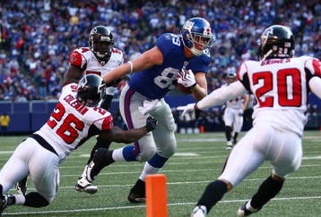 EAST RUTHERFORD, NJ - NOVEMBER 22:  Kevin Boss #89 of the the New York Giants fends off Erik Coleman #26 of the Atlanta Falcons to score a touchdown on November 22, 2009 at Giants Stadium in East Rutherford, New Jersey.  (Photo by Chris McGrath/Getty Images)