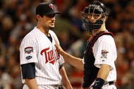 MINNEAPOLIS, MN - OCTOBER 11: Pitcher Carl Pavano #48 of the Minnesota Twins talks with catcher Joe Mauer #2 after Jorge Posada the New York Yankees hit a home run in the seventh inning to take a 2-1 lead in Game Three of the ALDS during the 2009 MLB Playoffs at the Hubert H. Humphrey Metrodome on October 11, 2009 in Minneapolis, Minnesota. (Photo by Genevieve Ross/Getty Images)