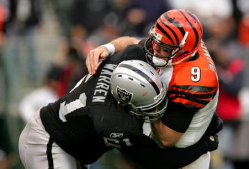 OAKLAND, CA - NOVEMBER 22:  Carson Palmer #9 of the Cincinnati Bengals is hit by Gerard Warren #61 of the Oakland Raiders at Oakland-Alameda County Coliseum on November 22, 2009 in Oakland, California.  (Photo by Ezra Shaw/Getty Images)