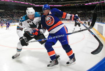 UNIONDALE, NY - OCTOBER 17: Kyle Okposo #21 of the New York Islanders is held back by Marc-Edouard Vlasic #44 of the San Jose Sharks at the Nassau Coliseum on October 17, 2009 in Uniondale, New York. The Sharks defeated the Islanders 4-1. (Photo by Bruce Bennett/Getty Images)