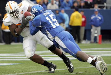LEXINGTON, KY - NOVEMBER 26:  Justin Harrell #92 of the Tennessee Volunteers with Curtis Pulley #15 of Kentucky hanging on, runs in for a touchdown after intercepting a pass during the game against the Kentucky Wildcats on November 26, 2005 at Commonwealth Stadium in Lexington, Kentucky. Tennessee won 27-8.  (Photo by Andy Lyons/Getty Images)