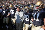 SOUTH BEND, IN - NOVEMBER 21: Head coach Charlie Weis of the Notre Dame Fighting Irish waits to enter the field with (L-R) Jimmy Clausen #7, Eric Olsen #55, Kyle McCarthy #28 and Scott Smith #41 before a game against the University of Connecticut Huskies at Notre Dame Stadium on November 21, 2009 in South Bend, Indiana. (Photo by Jonathan Daniel/Getty Images)