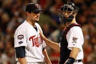 MINNEAPOLIS, MN - OCTOBER 11: Pitcher Carl Pavano #48 of the Minnesota Twins talks with catcher Joe Mauer #2 after Jorge Posada  the New York Yankees hit a home run in the seventh inning to take a 2-1 lead in Game Three of the ALDS during the 2009 MLB Playoffs at the Hubert H. Humphrey Metrodome on October 11, 2009 in Minneapolis, Minnesota. (Photo by Genevieve Ross/Getty Images)