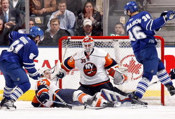 TORONTO - NOVEMBER 23: Phil Kessel #81 and Carl Gunnarsson #36 look for a loose puck in front of Dwayne Roloson #30 and Jack Hillen #38 of the Toronto Maple Leafs of the New York Islanders during game action November 23, 2009 at the Air Canada Centre in Toronto, Ontario, Canada. (Photo by Abelimages/Getty Images)
