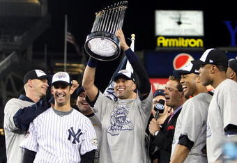 NEW YORK - NOVEMBER 04:  Derek Jeter #2 of the New York Yankees holds up the trophy as he celebrates with A.J. Burnett (L), Jorge Posada (2nd L), Mariano Rivera (2nd R) and Robinson Cano after their 7-3 win against the Philadelphia Phillies in Game Six of the 2009 MLB World Series at Yankee Stadium on November 4, 2009 in the Bronx borough of New York City.  (Photo by Jed Jacobsohn/Getty Images)