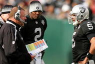 OAKLAND, CA - NOVEMBER 22: Oakland Raiders head coach Tom Cable speaks to his new starting quarterback Bruce Gradkowski #5 while newly benched quarterback JaMarcus Russell #2 looks on during their game against the Cincinnati Bengals at Oakland-Alameda County Coliseum on November 22, 2009 in Oakland, California. (Photo by Ezra Shaw/Getty Images)