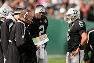 OAKLAND, CA - NOVEMBER 22: Oakland Raiders head coach Tom Cable speaks to his new starting quarterback Bruce Gradkowski #5 while newly benched quarterback JaMarcus Russell #2 looks on during their game against the Cincinnati Bengals at Oakland-Alameda County Coliseum on November 22, 2009 in Oakland, California. (Photo by Ezra Shaw/Getty Images)