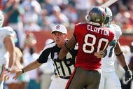 MIAMI GARDENS, FL - NOVEMBER 15: Referee Tony Corrente #99 tries to seperate wide receiver Michael Clayton #80 of the Tampa Bay Buccaneers from getting into a fight with Dolphin players while taking on the Miami Dolphins at Land Shark Stadium on November 15, 2009 in Miami Gardens, Florida. (Photo by Doug Benc/Getty Images)