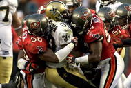 TAMPA, FL - NOVEMBER 22: Running back Lynell Hamilton #30 of the New Orleans Saints is tackled by linebackers Quincy Black #58 and Geno Hayes #54 of the Tampa Bay Buccaneers during the game at Raymond James Stadium on November 22, 2009 in Tampa, Florida. (Photo by J. Meric/Getty Images)