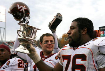 CHARLOTTESVILLE, VA - NOVEMBER 24:  Tackle Duane Brown #76 of the Virginia Tech Hokies celebrates with the Commonwealth Cup after defeating the Virginia Cavaliers 33-21 at Scott Stadium on November 24, 2007 in Charlottesville, Virginia.  (Photo by Kevin C. Cox/Getty Images)