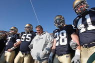 SOUTH BEND, IN - NOVEMBER 21: Head coach Charlie Weis of the Notre Dame Fighting Irish waits to enter the field with (L-R) Jimmy Clausen #7, Eric Olsen #55, Kyle McCarthy #28 and Scott Smith #41 before a game against the University of Connecticut Huskies at Notre Dame Stadium on November 21, 2009 in South Bend, Indiana. (Photo by Jonathan Daniel/Getty Images)