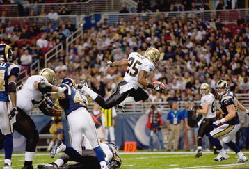 ST. LOUIS - NOVEMBER 15:  Reggie Bush #25 of the New Orleans Saints leaps for the endzone during the game against the St. Louis Rams at the Edward Jones Dome on November 15, 2009 in St. Louis, Missouri.  (Photo by Dilip Vishwanat/Getty Images)
