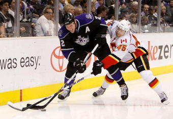 LOS ANGELES, CA - NOVEMBER 21:  Matt Greene #2 of the Los Angeles Kings and Jamie Lundmark #45 of the Calgary Flames battle for the puck along the boards in the third period at Staples Center on November 21, 2009 in Los Angeles, California. The Flames defeated the Kings 5-2.  (Photo by Jeff Gross/Getty Images)
