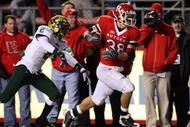 PISCATAWAY, NJ - NOVEMBER 12: Joe Martinek #38 of the Rutgers Scarlet Knights runs the ball past Quenton Washington #2 of the South Florida Bulls for a fourth quarter touchdown at Rutgers Stadium on November 12, 2009 in Piscataway, New Jersey. Rutgers won the game 31-0. (Photo by Jim McIsaac/Getty Images)