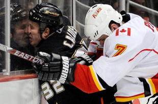 ANAHEIM, CA - NOVEMBER 23: Kyle Calder #32 of the Anaheim Ducks is checked against the glass by Adam Pardy #7 of the Calgary Flames during the first period of the NHL game at the Honda Center on November 23, 2009 in Anaheim, California. (Photo by Kevork Djansezian/Getty Images)