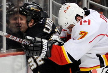 ANAHEIM, CA - NOVEMBER 23:  Kyle Calder #32 of the Anaheim Ducks is checked against the glass by Adam Pardy #7 of the Calgary Flames during the first period of the NHL game at the Honda Center on November 23, 2009 in Anaheim, California.  (Photo by Kevork Djansezian/Getty Images)