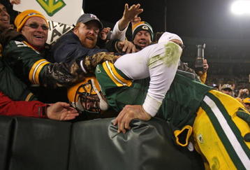 GREEN BAY, WI - NOVEMBER 15: Aaron Rodgers #12 of the Green Bay Packers leaps into the stands after scoring a touchdown against the Dallas Cowboys at Lambeau Field on November 15, 2009 in Green Bay, Wisconsin. The Packers defeated the Cowboys 17-7.  (Photo by Jonathan Daniel/Getty Images)